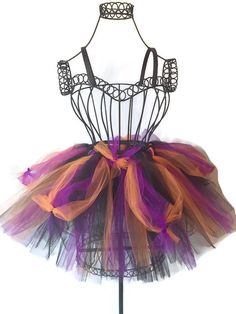 a purple and orange tutu skirt on a mannequin stand with a black headband