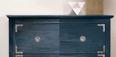 a blue dresser with metal handles and knobs