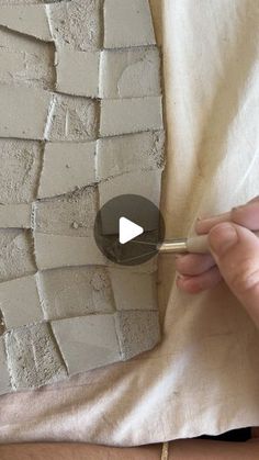 someone is making a wall out of clay