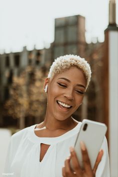 a woman smiling while looking at her cell phone