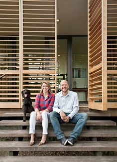 a man and woman sitting on steps next to a dog