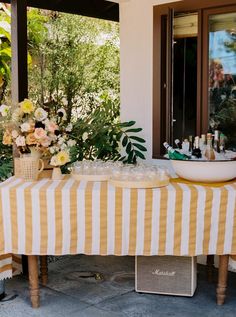 a table that has some drinks on it and flowers in the vases next to it