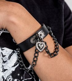 This gothic-inspired bracelet features a genuine leather strap and a stained alloyed heart lock. Crafted with superior quality materials, it is perfect for everyday wear. Show off your unique style with this beautiful bracelet. adjustable black leather bracelet with alloyed chains Black Punk Chain Bracelet As A Gift, Black Punk Style Chain Bracelet For Gift, Black Punk Style Chain Bracelet As Gift, Punk Style Black Chain Bracelet Gift, Black Metal Band Jewelry, Black Rock Style Jewelry For Streetwear, Rock Style Black Jewelry For Streetwear, Black Metal Emo Bracelets, Black Metal Emo Bracelet