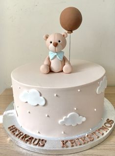 a birthday cake with a teddy bear holding a balloon