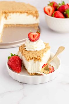 a piece of cake on a plate with strawberries in the bowl next to it