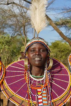 an african woman wearing colorful headdress and feathers