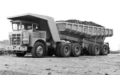 an old dump truck is parked in the dirt