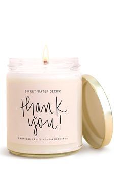 a white candle with the words thank you written on it and a gold lid in front of a white background