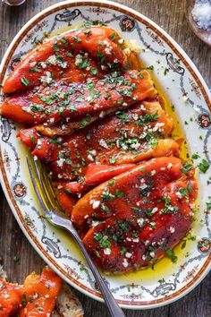 two plates filled with cooked carrots covered in marinara sauce