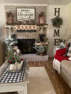 a living room decorated for christmas with white and red decorations on the fireplace mantel