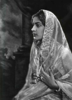 an old black and white photo of a woman wearing a veil