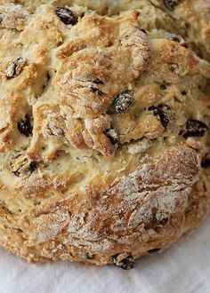 two loaves of bread sitting on top of a piece of white paper with raisins