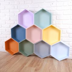 several hexagonal trays stacked on top of each other in front of a brick wall