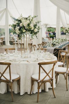 the tables are set with white tablecloths and centerpieces