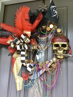 a halloween wreath with skulls, feathers and other decorations on it's front door