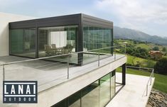 a balcony with glass railings and chairs on the top floor, overlooking rolling hills