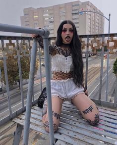 a woman sitting on top of a metal bench