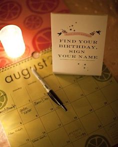 a calendar with a pen on it next to a candle