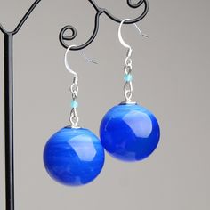 "These Blue ball dangle earrings are good for everyday outfits and for special occasions. They can be a great gift for her! Dimensions: total length is 2\" inch (5cm), ball diameter 0.9\" inch (2.2cm). Materials: artist lampwork glass beads, silver plated hooks. Colors used: blue. For your information: ✦ Get free shipping when you buy any two or more items! ✦ All jewelry is shipped with some kind of gift wrapping, box or bag depending on size. ✦ Your order will be packed very carefully and will Trendy Light Blue Dangle Earrings, Trendy Light Blue Drop Earrings, Trendy Blue Sterling Silver Earrings, Trendy Blue Round Bead Earrings, Blue Sterling Silver Earrings With French Hook, Sterling Silver Blue French Hook Earrings, Blue Dangle Earrings With French Hook, Blue Hypoallergenic Round Bead Earrings, Blue Hypoallergenic Earrings With Round Beads