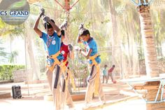 two boys in blue shirts and tan pants are performing aerial acrobatics