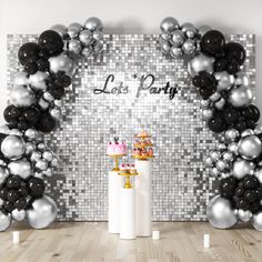 a party with balloons, cake and confetti in front of a silver sequin wall