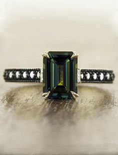 emerald cut green sapphire ring, black rhodium band caption:3.04ct. Emerald Cut Sapphire 14k Yellow Gold  | Different engagement ring styles Big Diamond Engagement Rings, Green Sapphire Ring, Emerald Cut Engagement, Handmade Engagement Rings, Emerald Engagement Ring Cut, Gemstone Engagement, Ethical Jewelry, Engagement Ring Cuts, Green Sapphire