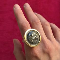 This is a large version of our signet ring design that is based off a pontiffs intaglio ring for wax seals. The coin set in the ring is an oxidized silver casting of a vintage greek coin featuring Alexander The Great. Oxidized silver has a beautiful historic feel for jewelry (think Austro-Hungarian empire) and is a wonderful contrast to the yellow gold. MATERIAL: 18k yellow gold, Oxidized Silver DIMENSIONS: 1.25″ diameter Signet Ring Design, Silver Casting, Greek Coins, Mixed Metal Jewelry, Coin Set, Coin Ring, Alexander The Great, Ring Sale, Sapphire Pendant