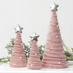 three pink christmas trees with silver stars on them