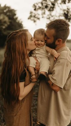 a man and woman holding a baby in their arms