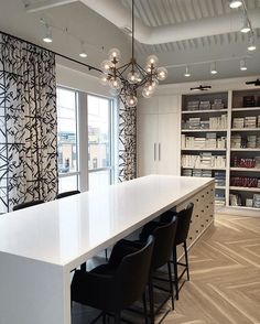 a large white table with black chairs in a room