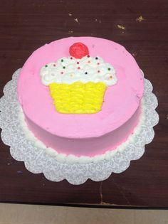 a pink cake with white frosting and a cherry on top