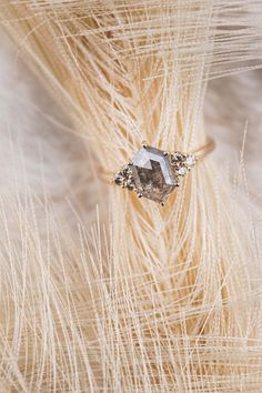 a diamond ring sitting on top of some dry grass