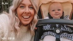 a woman holding a baby in a stroller smiling at the camera and posing for a photo