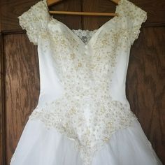 a white dress hanging on a wooden hanger