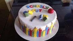 a birthday cake decorated with colorful crayons and the words school's out