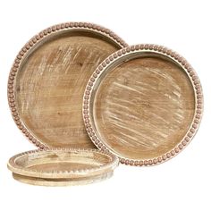 three wooden plates with beaded trims on the edges and one empty plate in front