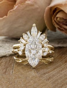 a close up of a ring on a wooden surface with flowers in the back ground