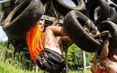 a man hanging upside down on some tires