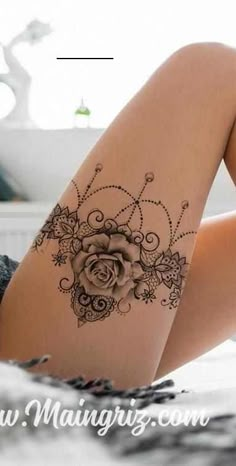 a woman laying on her stomach with a rose tattoo on her thigh and the bottom half of her leg