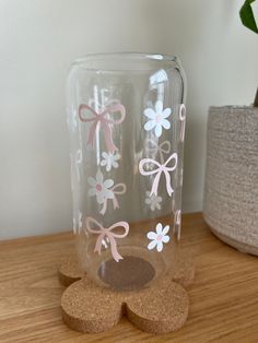 two vases with bows on them sitting on a table next to a potted plant