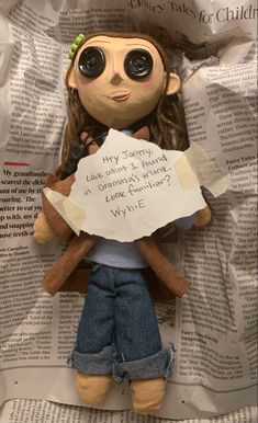 a stuffed doll holding a paper with writing on it