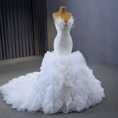 a white wedding dress on display in front of a mannequin headdress