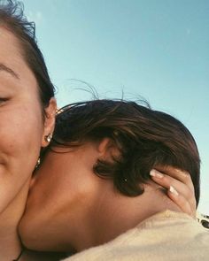 two women hugging each other on the beach