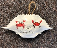 a sign that says the crabby court hanging on a carpeted area with two crabs