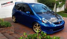 a blue car parked in front of a garage