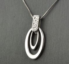 "14 KARAT WHITE GOLD MODERN PENDANT WITH HIGH POLISH . AVAILABLE SAME STYLE EARRINGS metal-14kwg weight-3.4gm FOR ADDITIONAL QUESTIONS ABOUT THIS PRODUCT: Please feel free to message us. We are quick to respond to all your inquiries. PLEASE choose as \"FAVORITE\" on the right so the item will be added to your favorites list and you may always revisit it. CUSTOM ORDERS: Please feel free to contact us if you could not find the piece you had in mind. We know how important it is to find the right je Oval White Gold Necklace With Elegant Design, White Gold Oval Necklace With Elegant Design, White Gold Diamond Necklace With Oval Sterling Silver Pendant, White Gold Sterling Silver Diamond Necklace With Oval Pendant, Modern Brilliant Cut Diamond Pendant Necklace, Modern Silver Diamond Necklace, Modern White Gold Diamond Necklace With Polished Finish, Fine Jewelry In White Gold With Shiny Finish, Modern White Gold Teardrop Pendant Jewelry