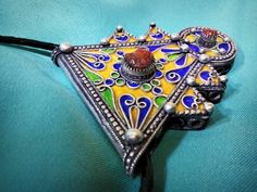 Ancient Berber talisman (herz) in sterling silver, enamelled in blue, green and yellow color. and decorated with a real coral cabochon. Height: 7 cm. Width: 5.5 cm. Leather: 54 cm. ++Material: sterling silver 925, real coral cabochon. ++Weight: 31.8 grams. ++ Origin: Morocco 1970s. Free worldwide shipping by DHL. I am always open to offers for one of my items, so please contact me if you would like to make an offer. Don't hesitate to contact me for any questions. All items advertised for sale ar Vintage Locket Jewelry For Festivals, Vintage Festival Locket Jewelry, Unique Heart-shaped Festival Jewelry, Bohemian Ceremonial Locket Jewelry, Antique Jewelry For Festivals And Gifts, Traditional Handmade Heart Jewelry, Traditional Handmade Heart-shaped Jewelry, Bohemian Locket Necklace For Ceremonial Use, Bohemian Locket Necklace For Ceremonial Occasions