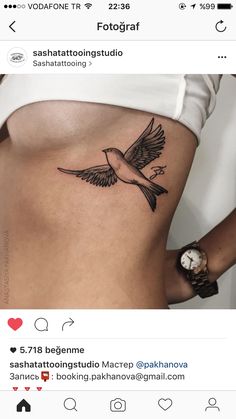 a woman's stomach with a bird tattoo on it