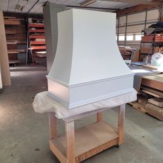 a large white stove top sitting in a room next to some wood pallets and boxes