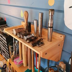 a wooden table topped with lots of different types of knives and other items on top of it